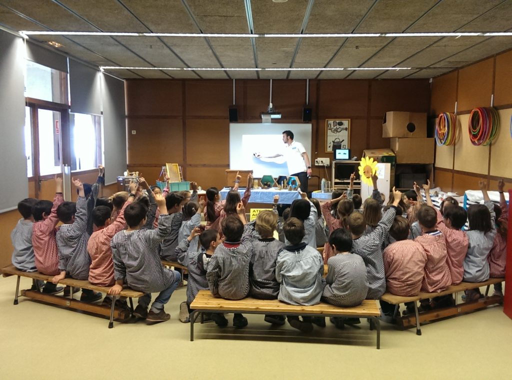 Un grup de nens reben una classe d'apicultura. Aquestes classes formen part dels serveis apícoles.